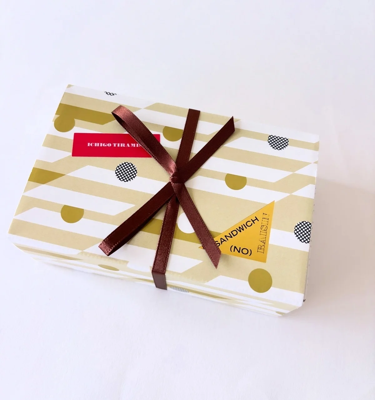 「ノーレーズンサンドイッチ＜いちごティラミス＞」の箱パッケージには、リボンをあしらって