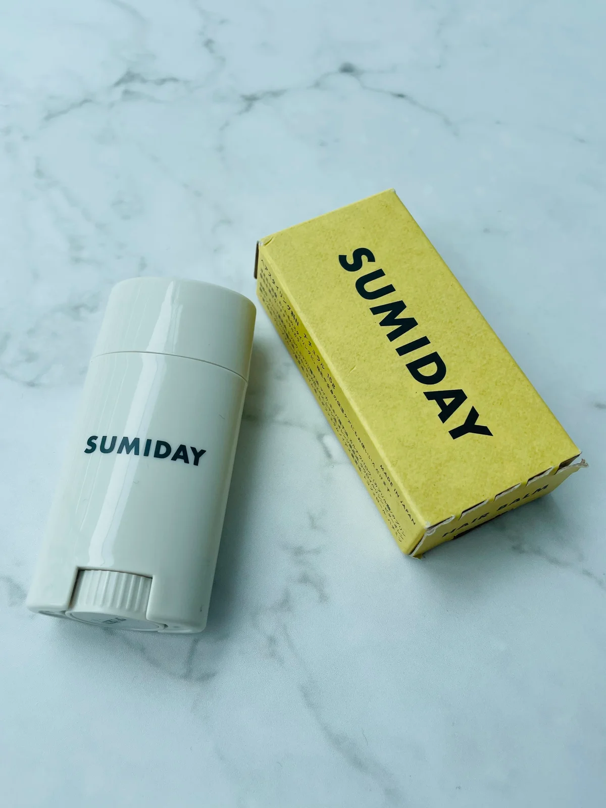 SUMIDAYのヘアバームのパッケージと商品を一緒に並べた写真