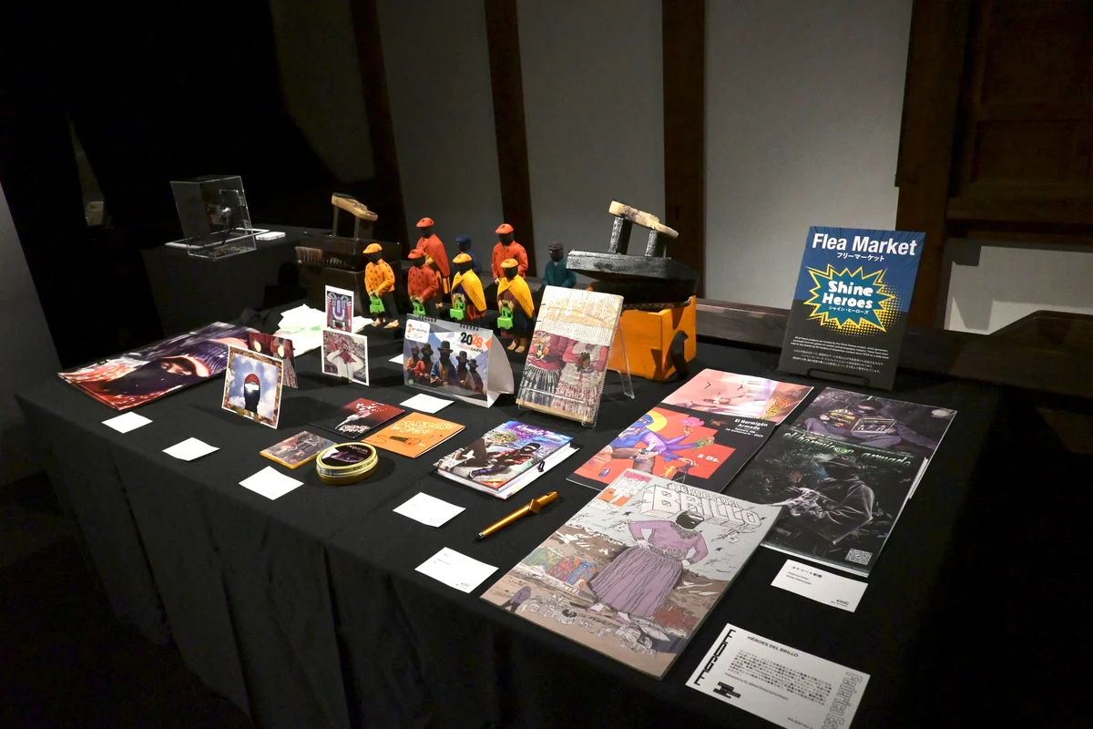 KYOTOGRAPHIE2026 フェデリコ・エストルさんの「シャイン・ヒーローズ」の展示会場で販売されているグッズ