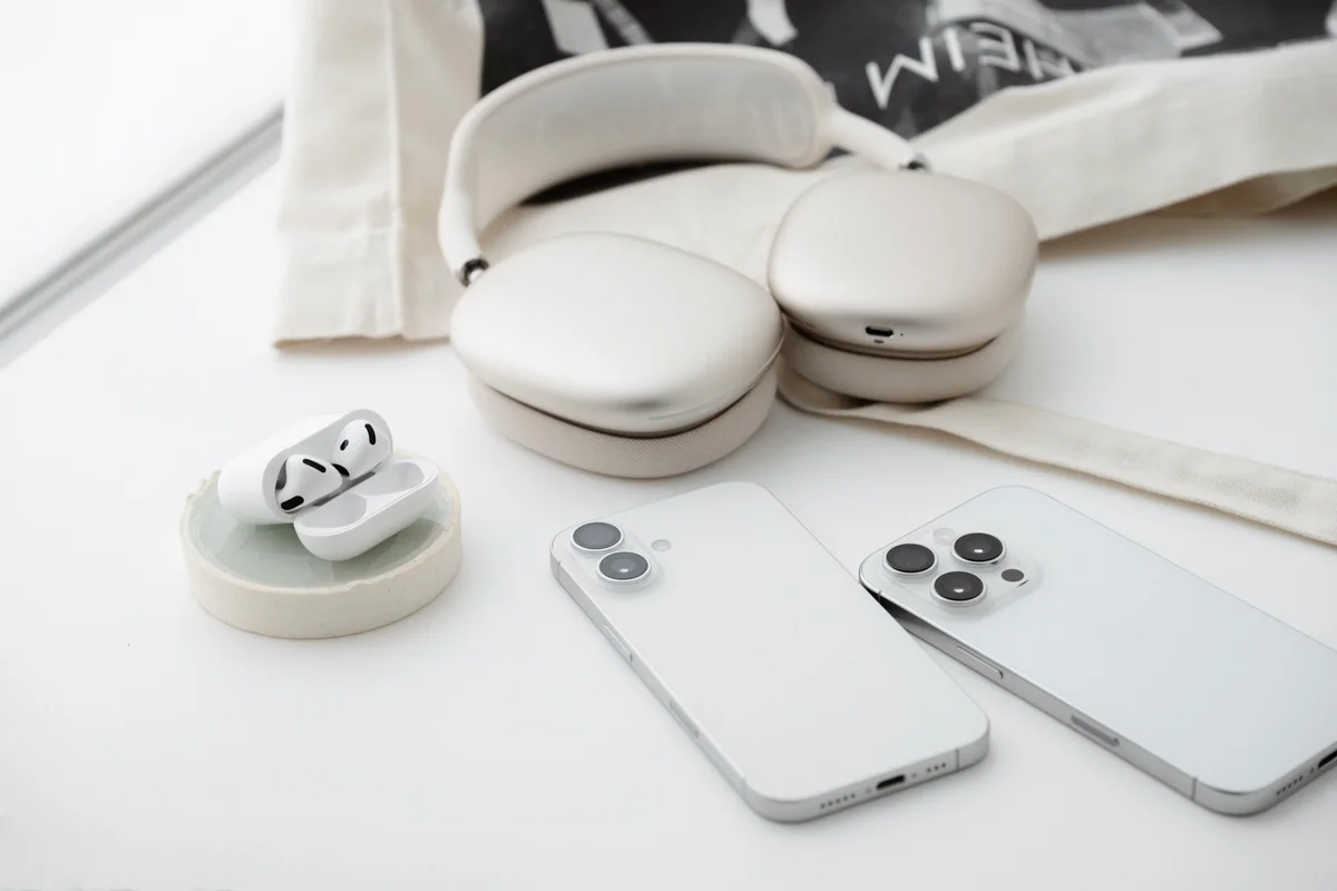 左から時計回りにAirPods 4、AirPods Max（スターライト）、iPhone 16 Pro（ホワイトチタニウム）、iPHone 16（ホワイト）