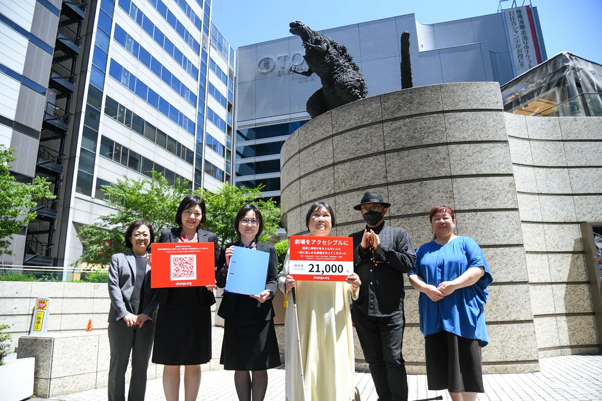 ゴジラ像のある東宝株式会社前に立つ、６人の署名活動メンバーの写真