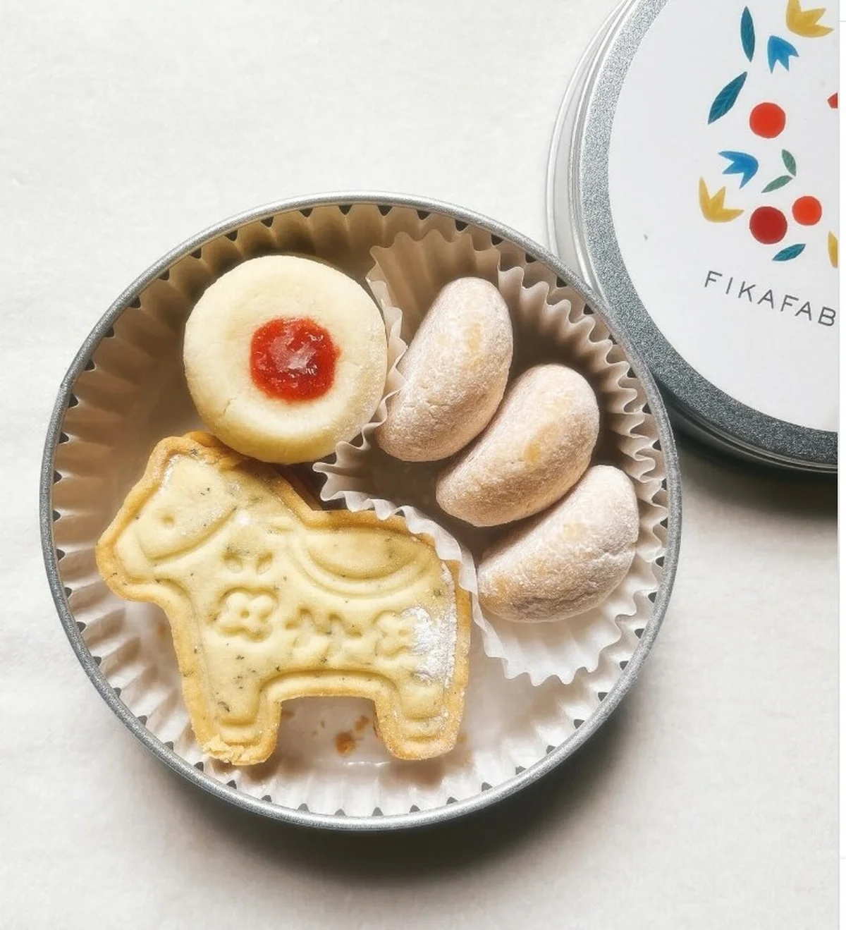 FIKAFABRIKEN（フィーカファブリーケン）のクッキー缶。ダーラナホースを象った紅茶のクッキー、スノーボール、ラズベリージャムクッキーが入っている。