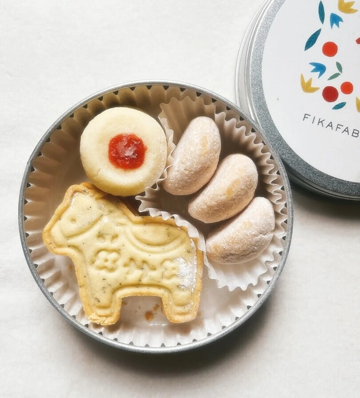 FIKAFABRIKEN（フィーカファブリーケン）のクッキー缶。ダーラナホースを象った紅茶のクッキー、スノーボール、ラズベリージャムクッキー入り