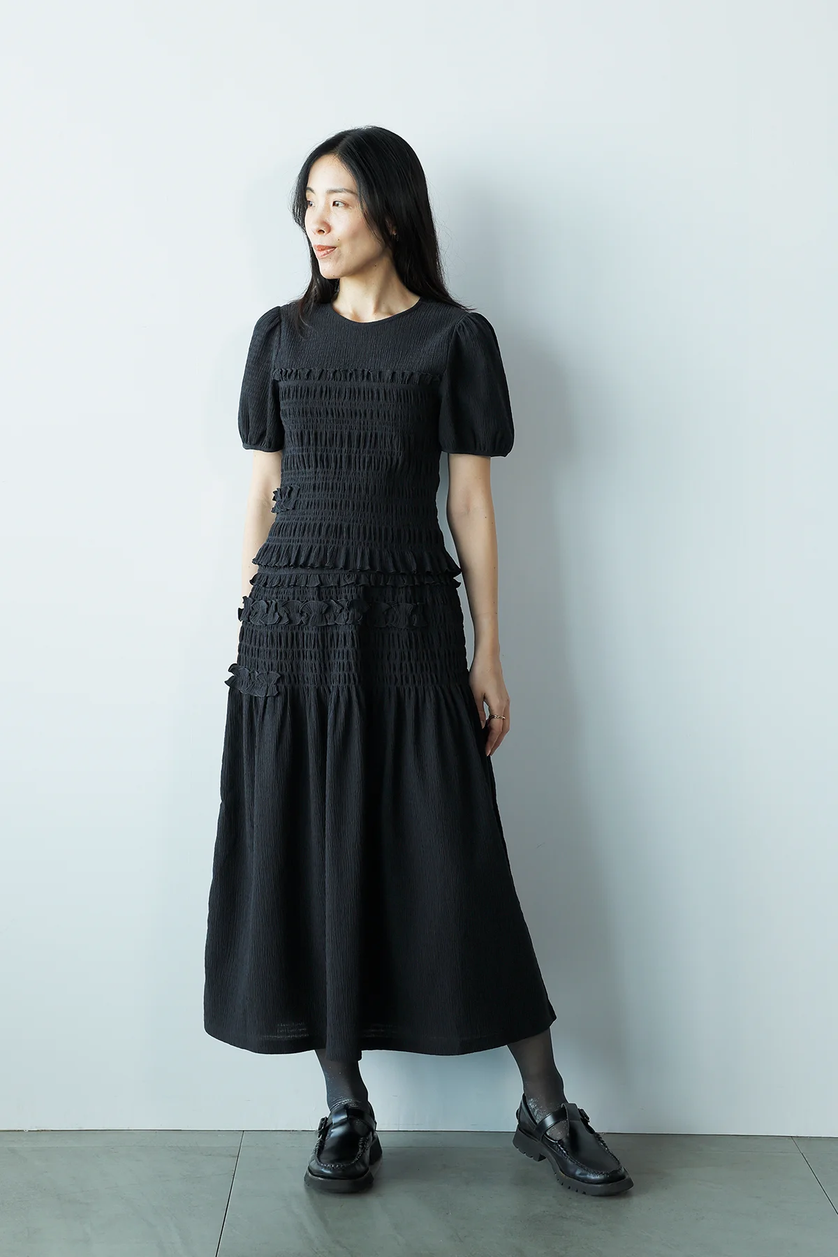 ユニクロ アンド セシリー バンセンのシャーリング ボリューム スリーブTとシャーリング スカートを着用したエディター