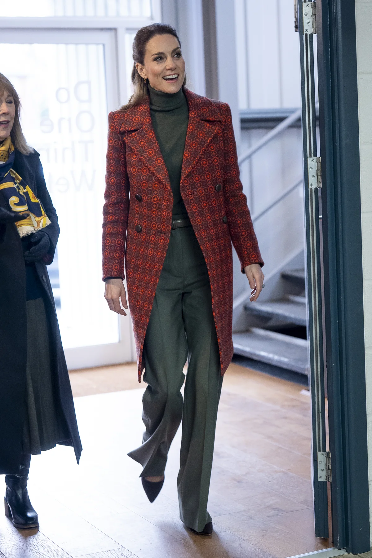 赤いタペストリーコートに、ヴィクトリア ベッカムのカーキ色のパンツを合わせたキャサリン皇太子妃
