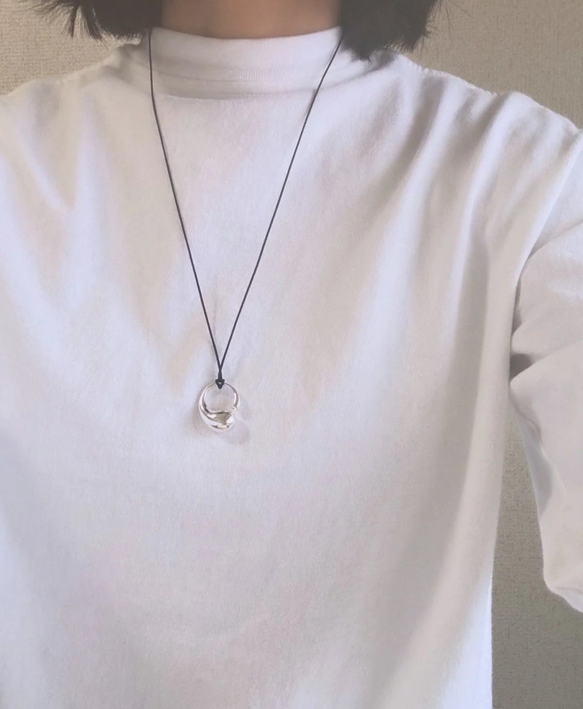 ジョージ ジェンセンの 「マーシー」ペンダント（M）を白いカットソーで着用。長さを一番長くしたバージョン。トップが胸元の下くらいに