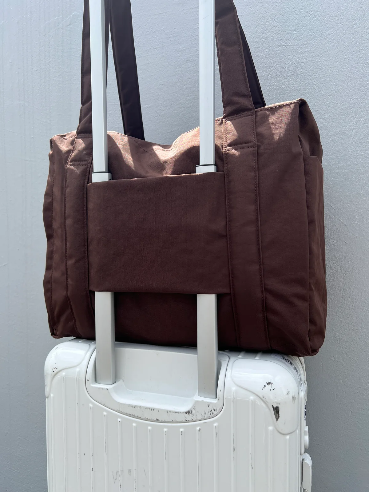 BAGGU「SMALL CLOUD CARRY ON」をキャリーケースにさしたところ