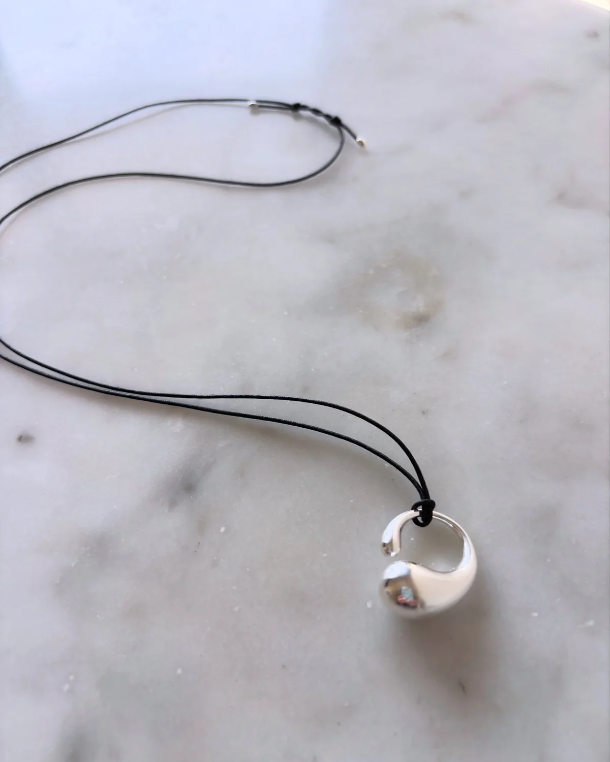 ジョージ ジェンセンの新作 「マーシー」ペンダント（M）は、有機的なフォルムのシルバートップが特徴。