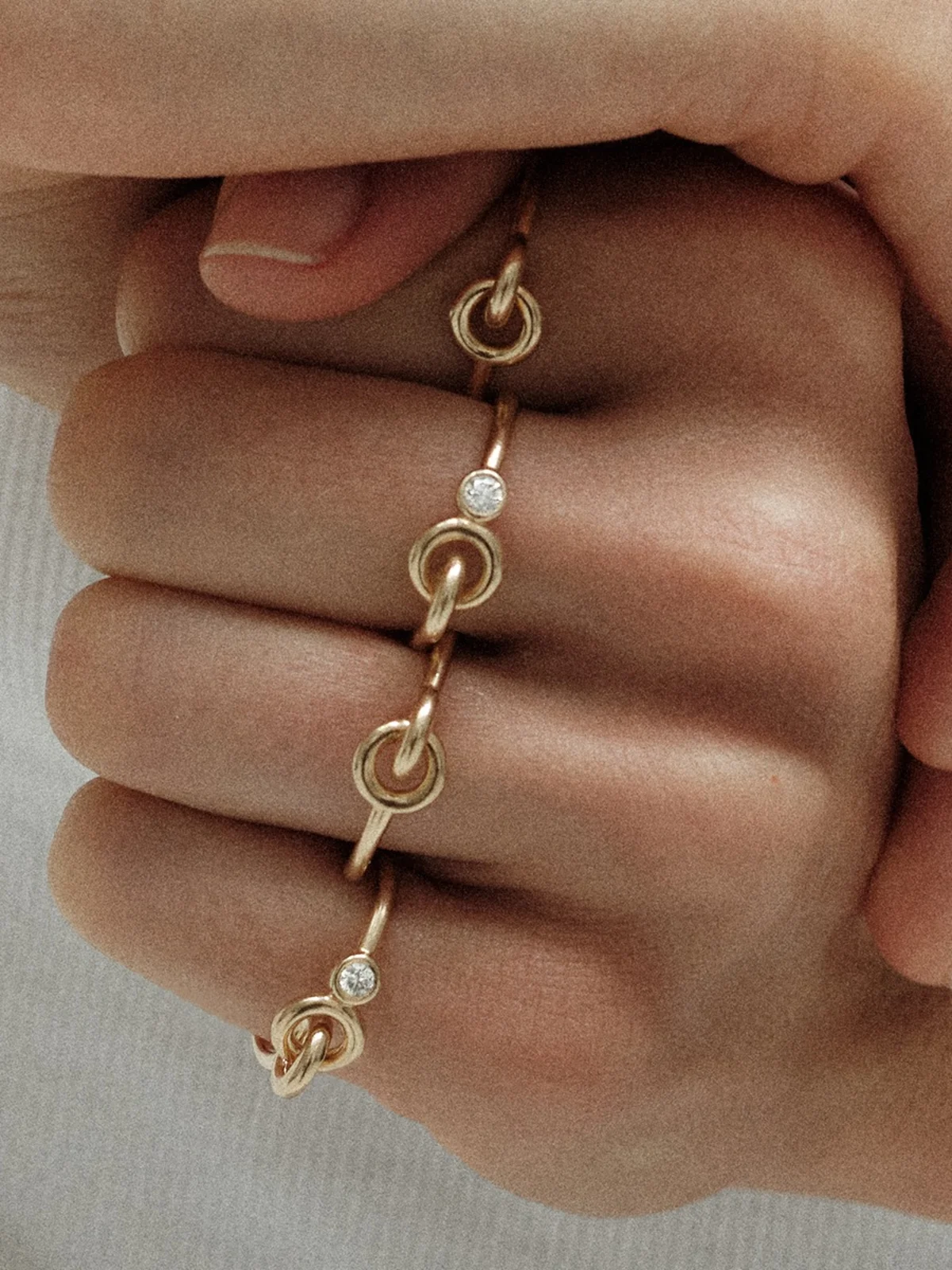 シャルロット シェネのTWINリングを手に身につけて。まるで知恵の輪のような、ひねりのきいた幾何学的なデザイン