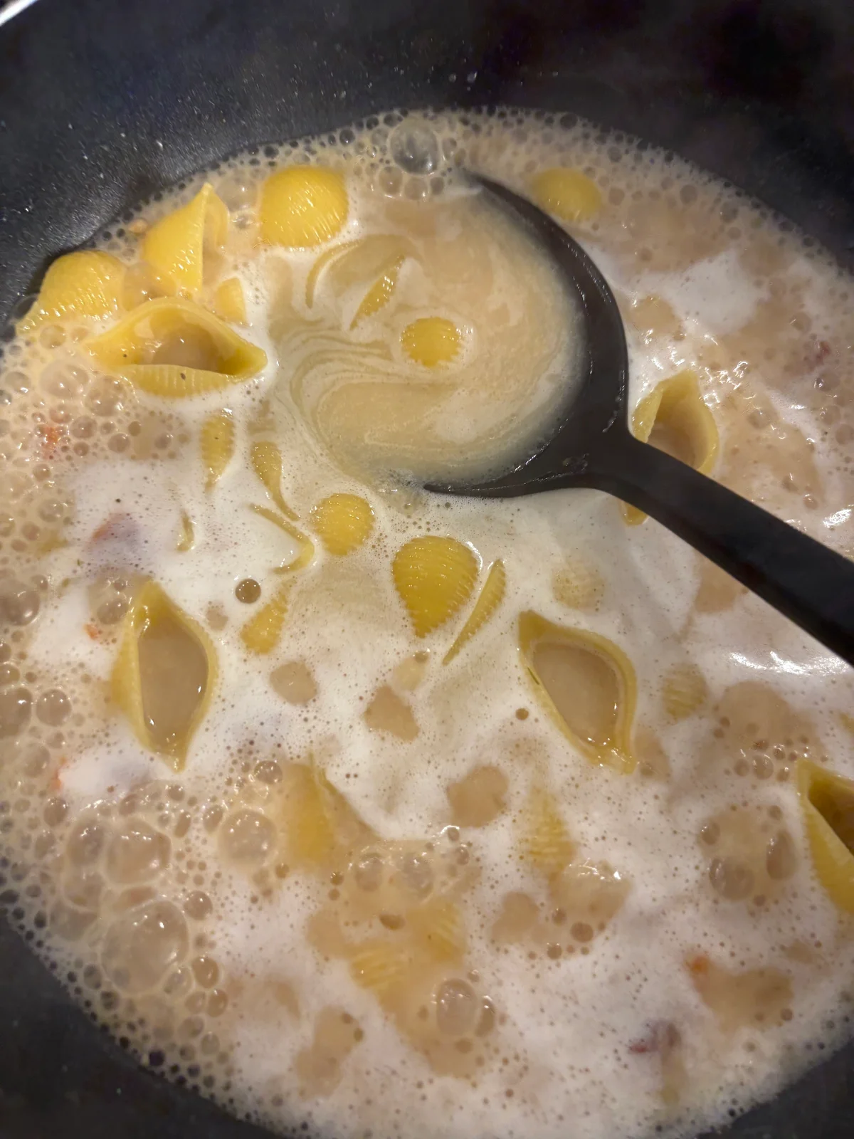 無印良品の煮込んでつくるスープパスタの素「サーモンとマスカルポーネクリーム」をフライパンで調理している写真