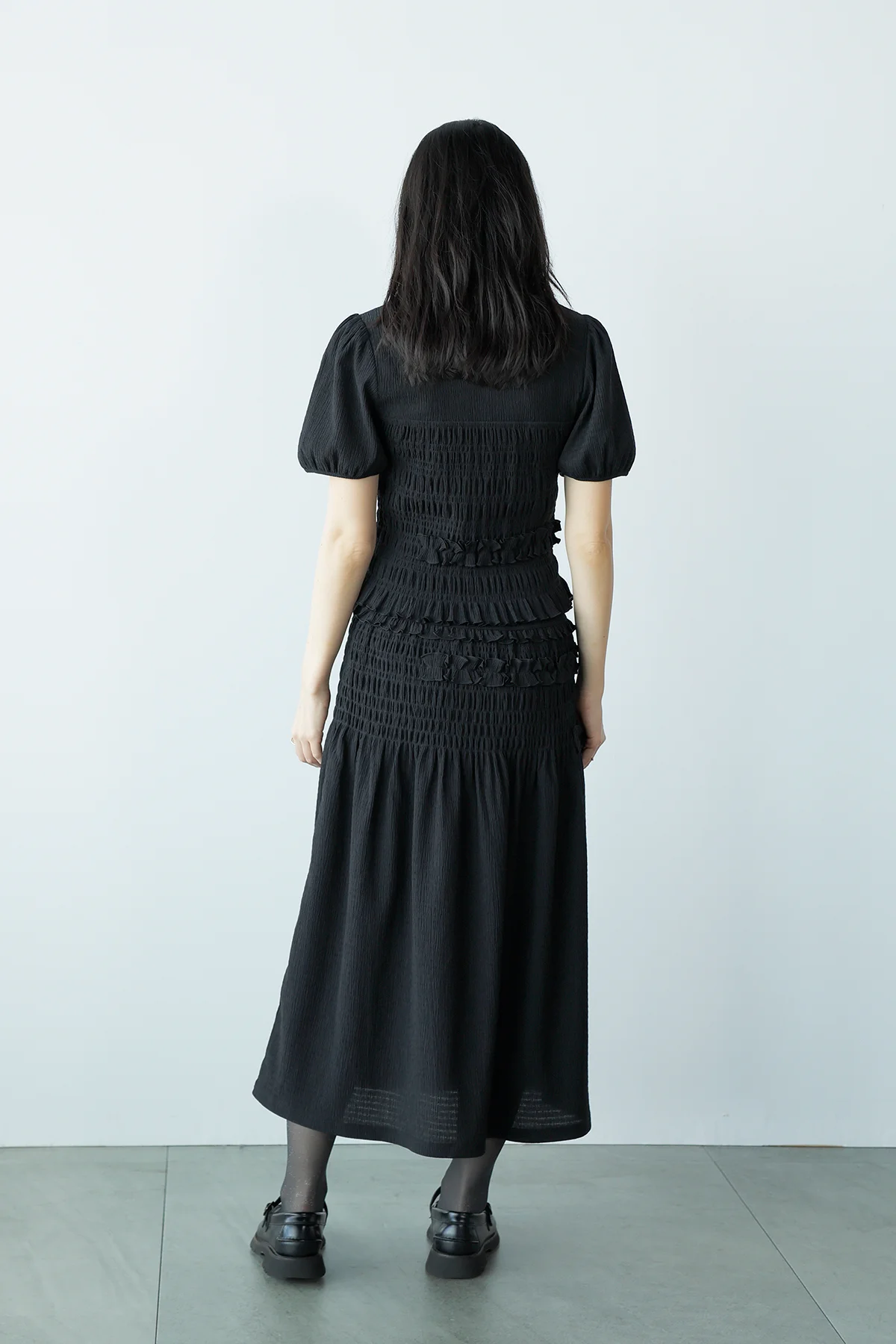 ユニクロ アンド セシリー バンセンのシャーリング ボリューム スリーブTとシャーリング スカートを着用した後ろ姿