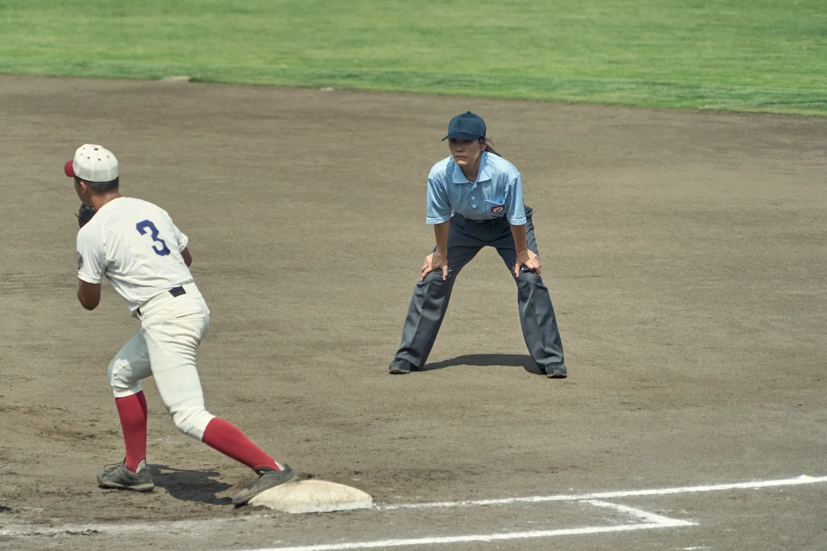 グラウンドで一塁の塁審をする、高校野球審判委員の佐藤加奈さん