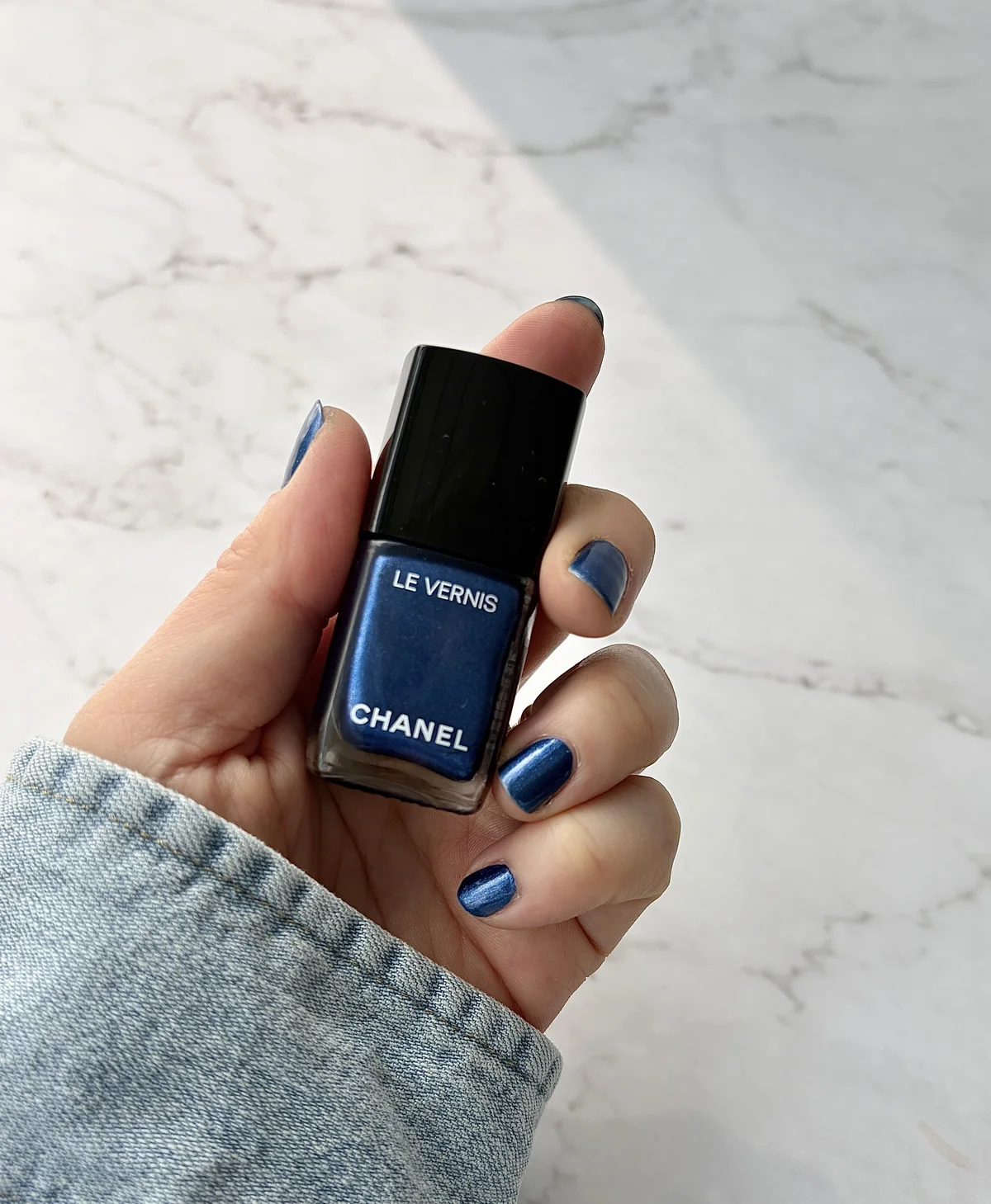 シャネル  ヴェルニ 419 レジャンド を爪に塗りネイルを持った手元のアップ