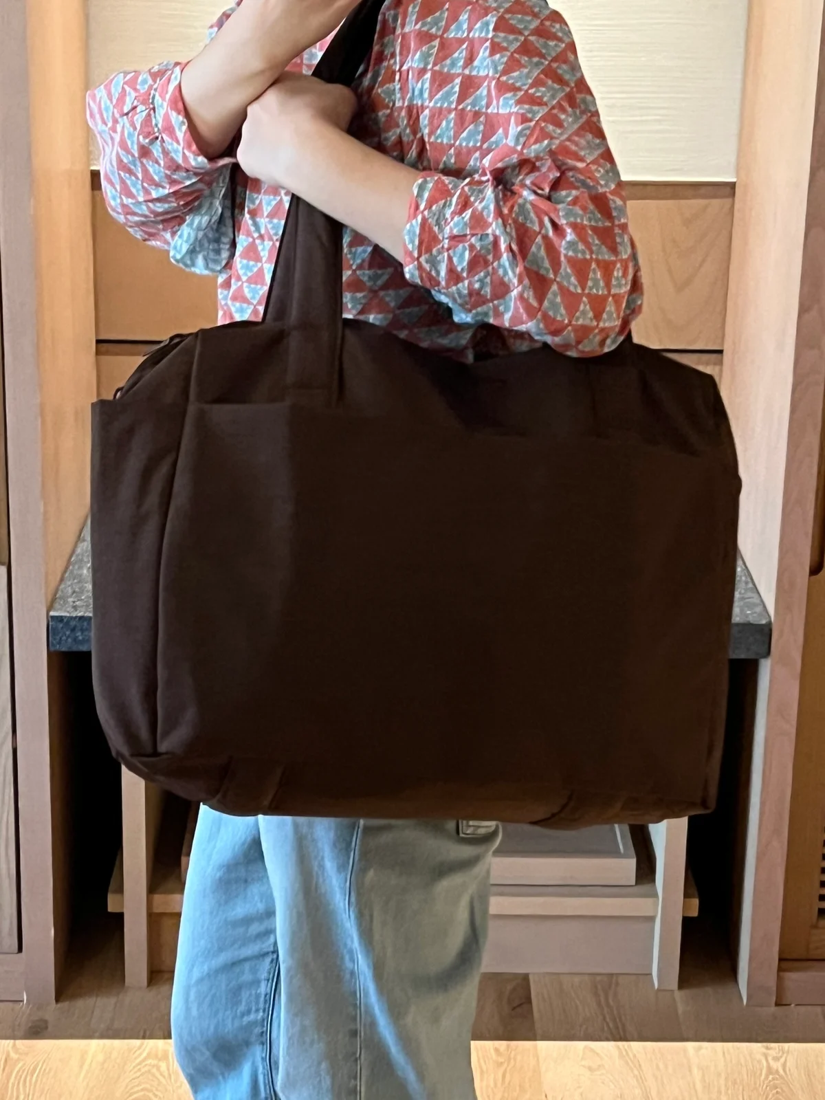 BAGGU「SMALL CLOUD CARRY ON」を肩にかけて持ったところ