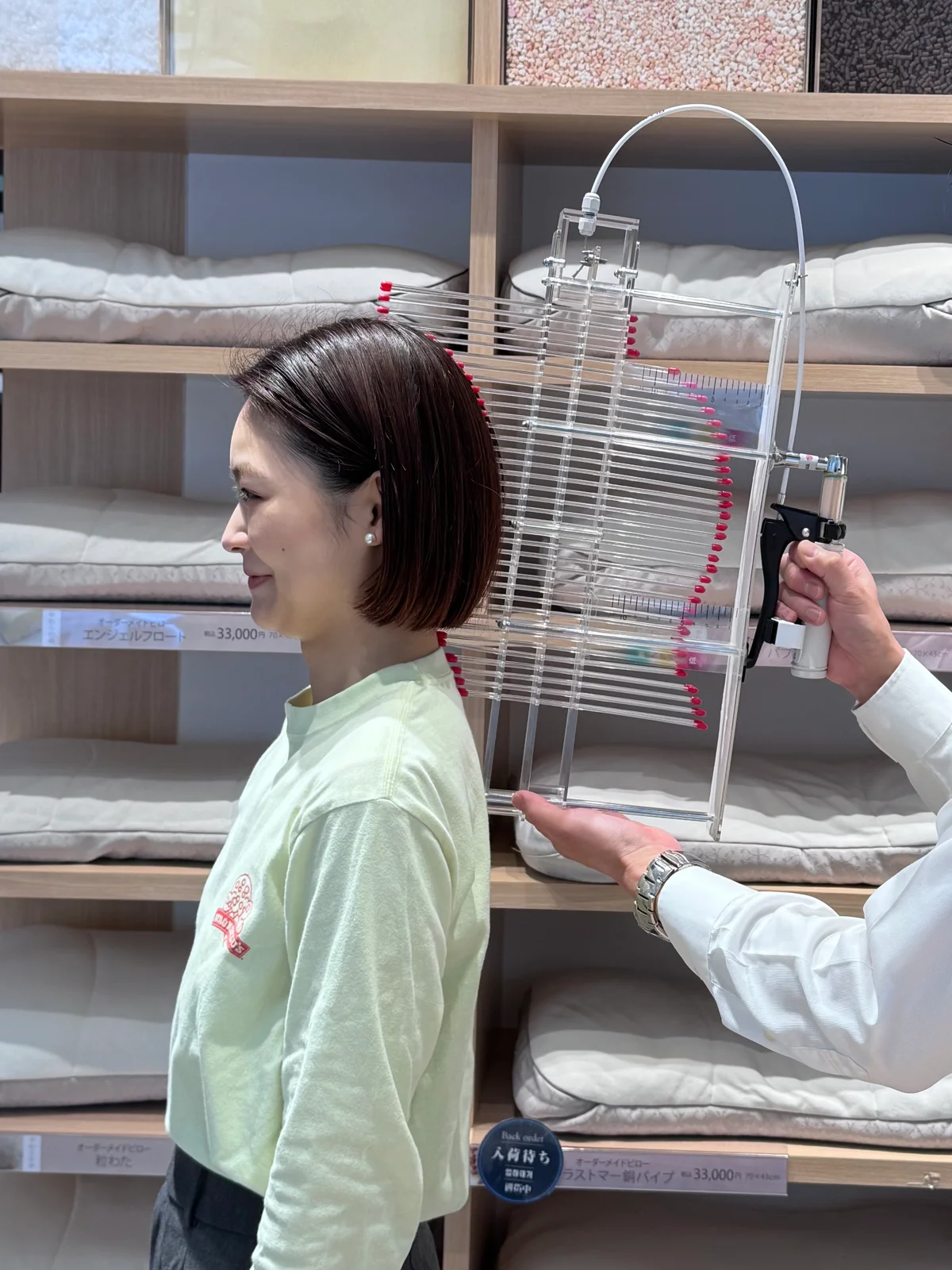 西川のオーダーメイド枕を作るため、「オリジナル測定器」で後頭部や首の高さを確認している様子