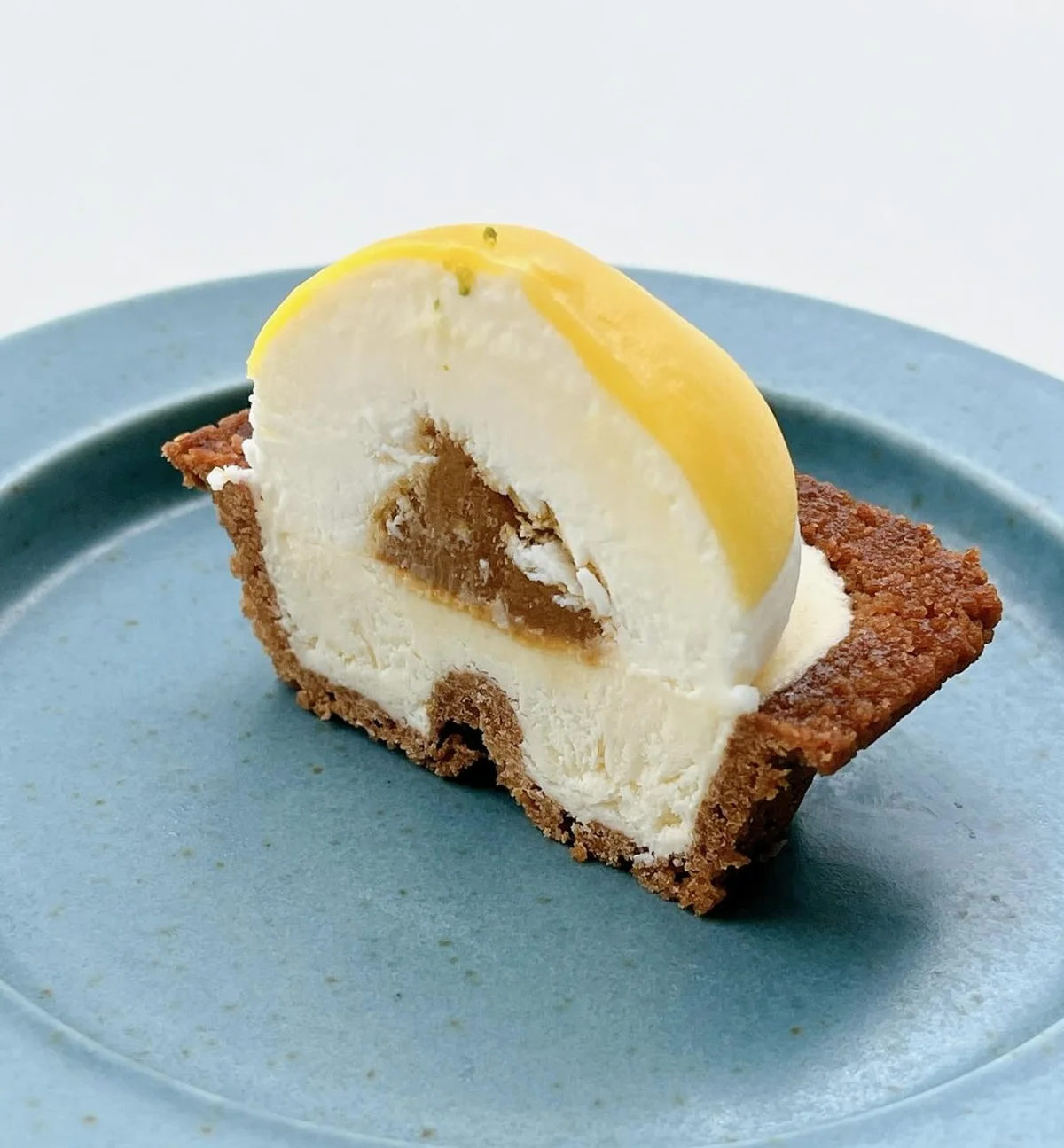 チーズワンダーの生チーズケーキ断面図。生チーズスフレと生チーズムースの二層構造。真ん中で割ると食べやすく、横から見るとブランドのWが表現されている！