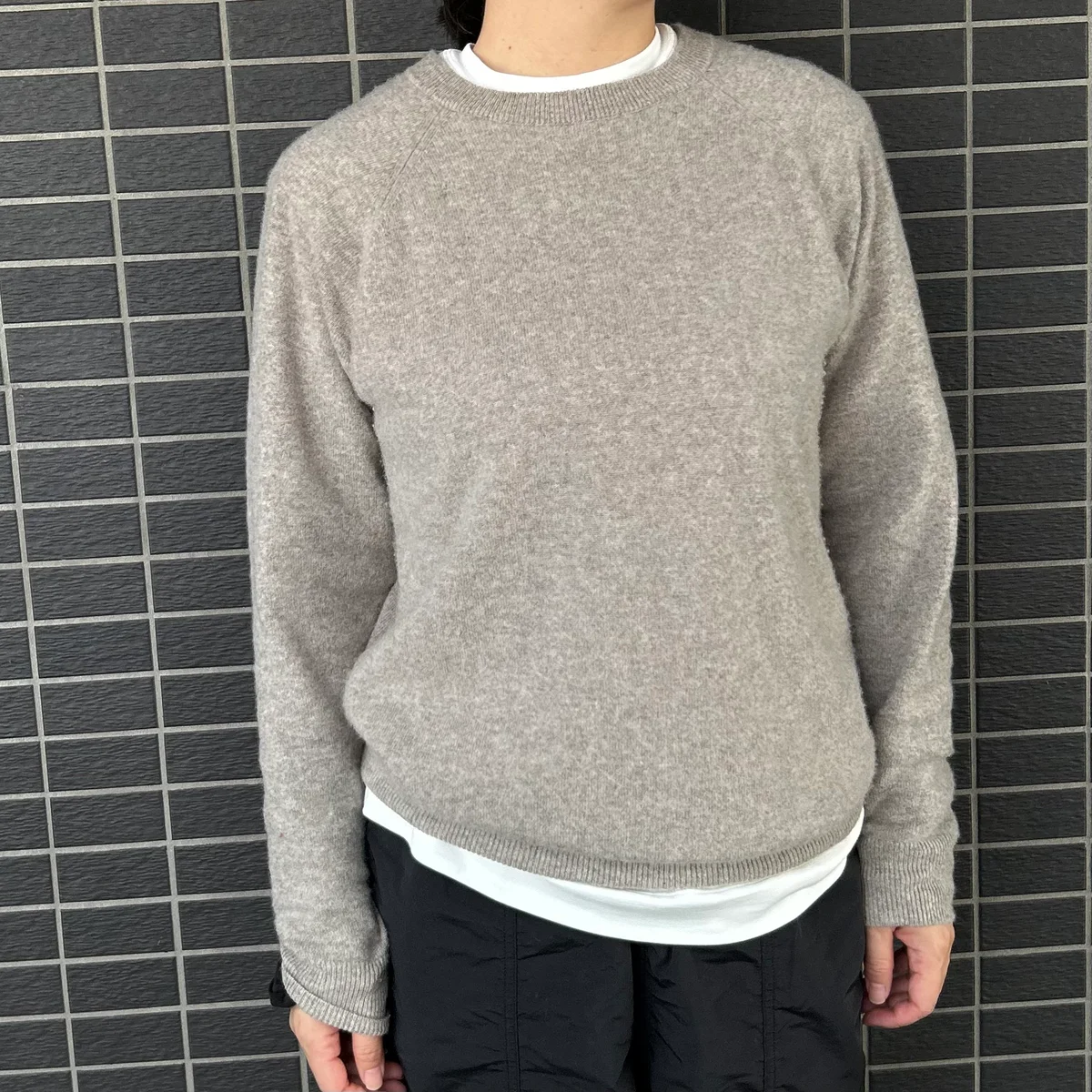 BOWTEの白Tシャツをニットと重ねて着た写真