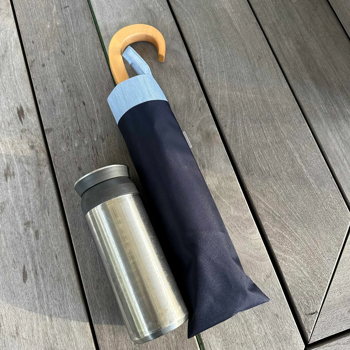 サンバリア100の折りたたみ日傘 ２段折 / コンビのネイビー(木曲がり手元)を500mlの水筒と比較