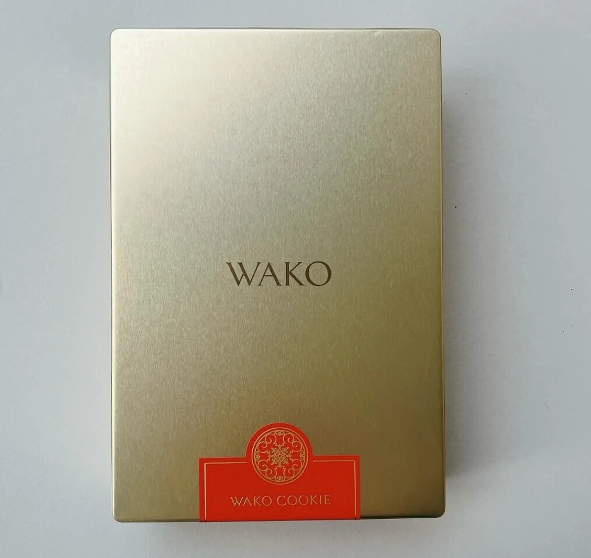 品のよいシャンパンゴールドの缶パッケージの写真。缶を開けると、市松模様のように2種のクッキーが交互に詰め合わせられている。