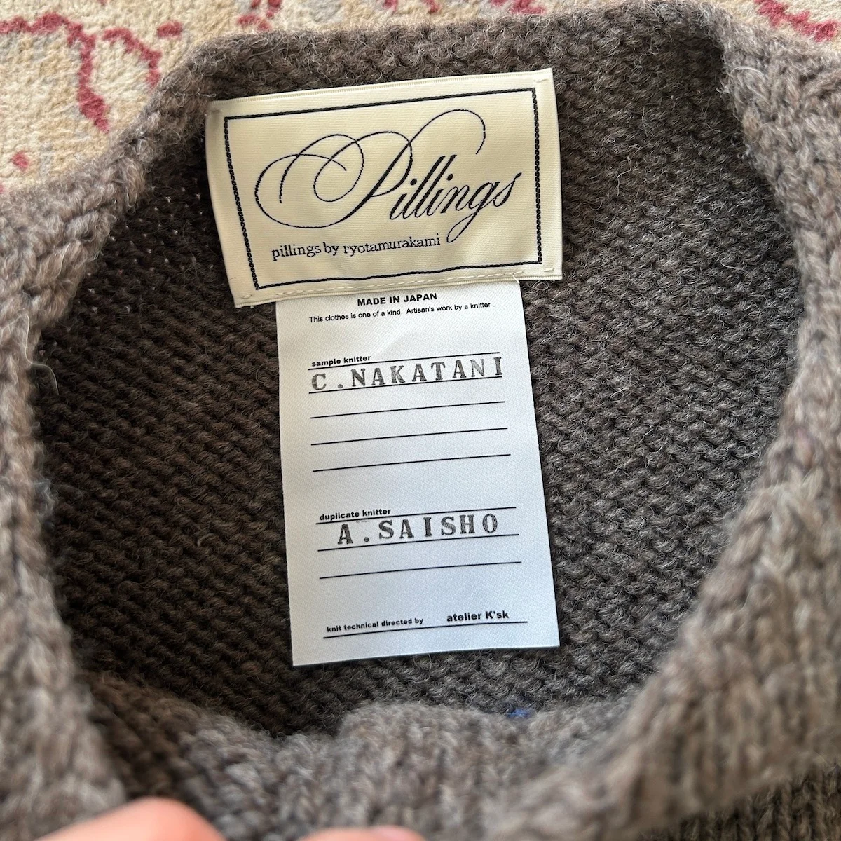 ピリングスのカーディガンのネームタグ