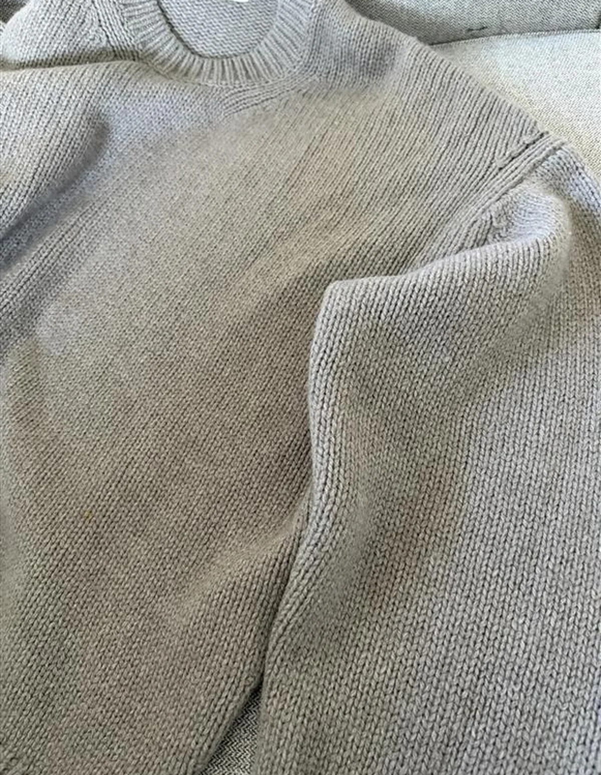 毛玉取り器を当てて毛玉を除去した厚手のニットの画像