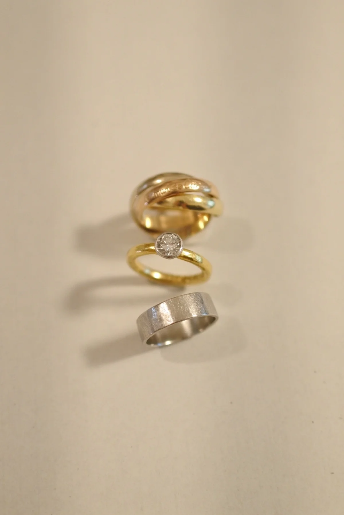 母から譲り受けたトリニティを婚約指輪に重ね、ゴールドのグラデーションを楽しむのが最近のお気に入り。上から：リング／カルティエ　エンゲージメントリング・マリッジリング／ともに装身具LCF
