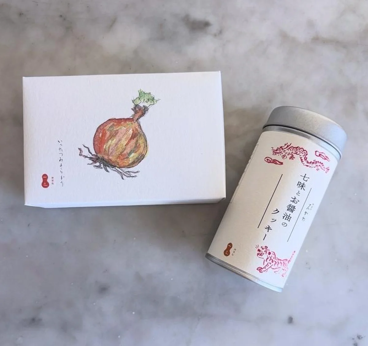 左から：神楽坂 石かわ「焼き玉ねぎクッキー」￥3,780、「七味とお醤油のクッキー」￥2,970／いったつみとらどう＊ともに羽田空港限定