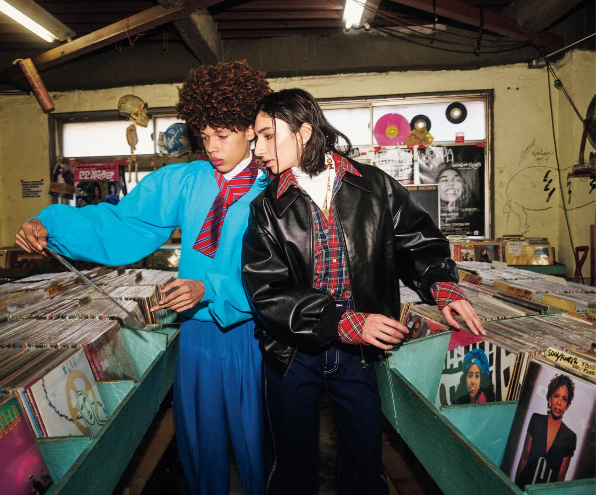 セリーヌのジャケット、スウェット、シャツ、白トップス、ネクタイ、デニム、パンツを着用したモデル　