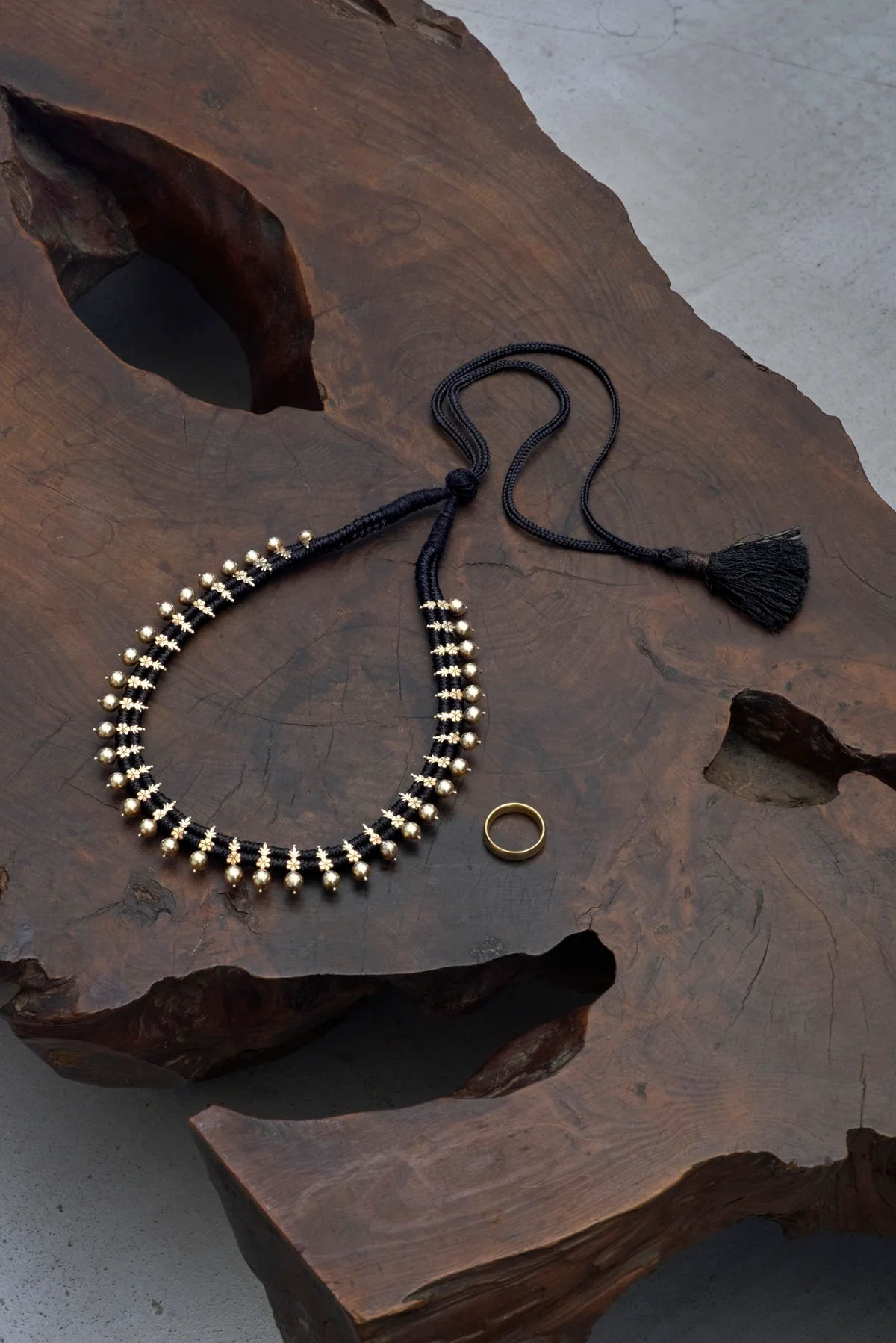 婚約の証となった、エンドパーツに施されたタッセルも印象的なネックレス。のちに購入したシハラのゴールドの結婚指輪とも相性抜群だ。