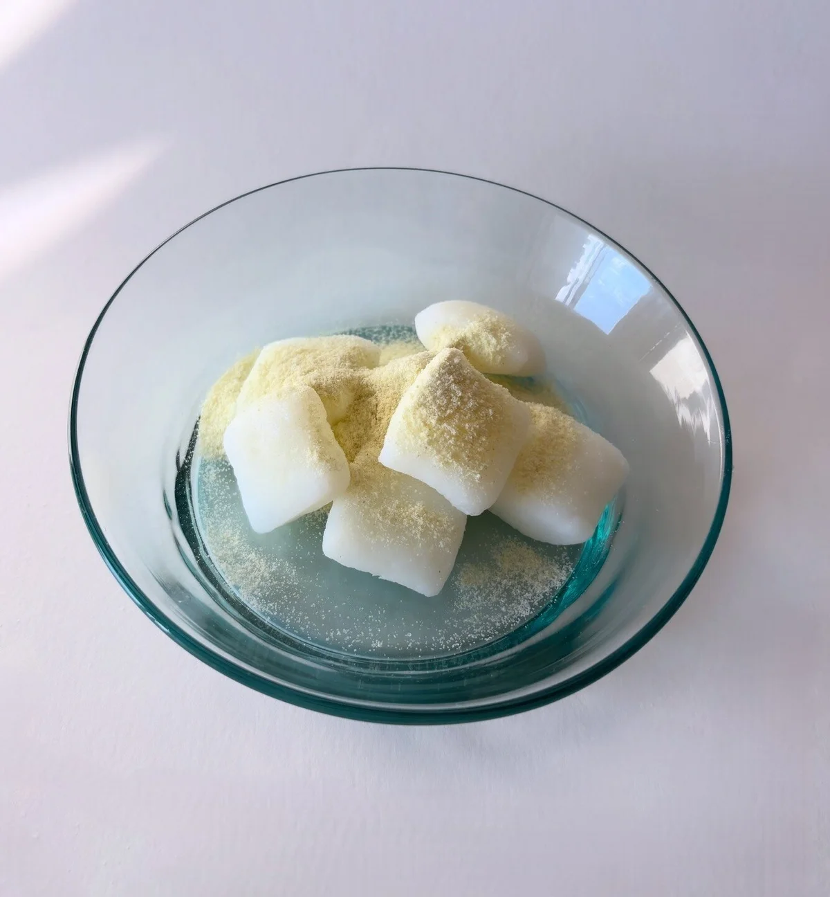 水だんごは水で打ち粉を流し、青きな粉をかけて食べる