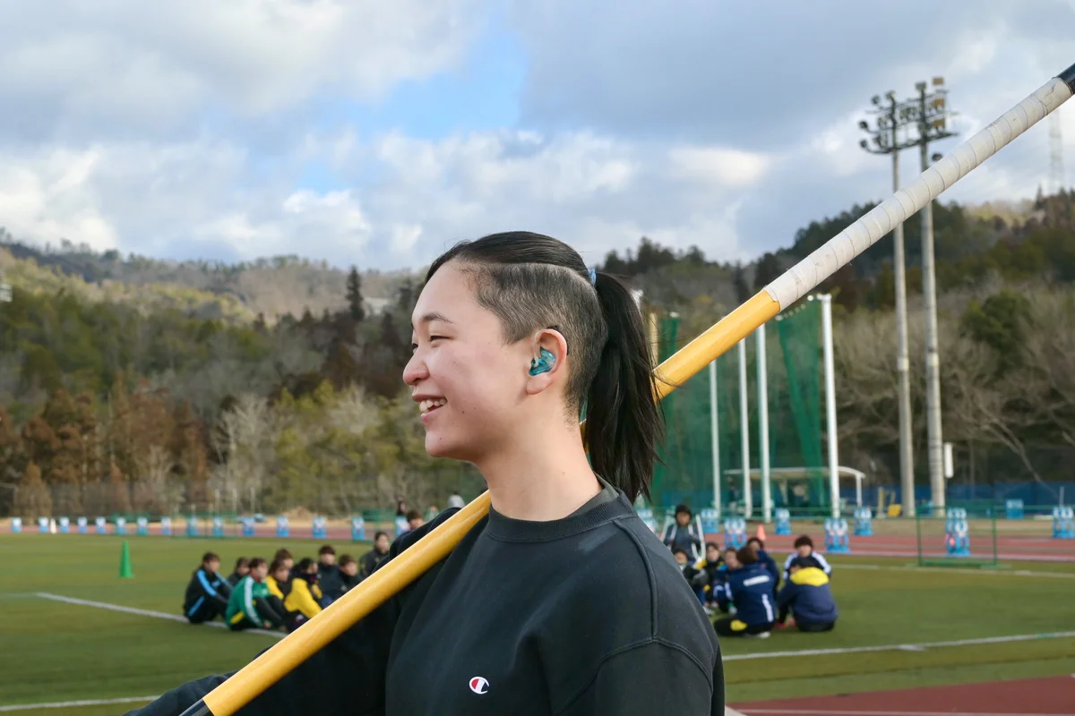 ポールを持ち、明治国際医療大学の練習場に立つ末吉凪さんの写真