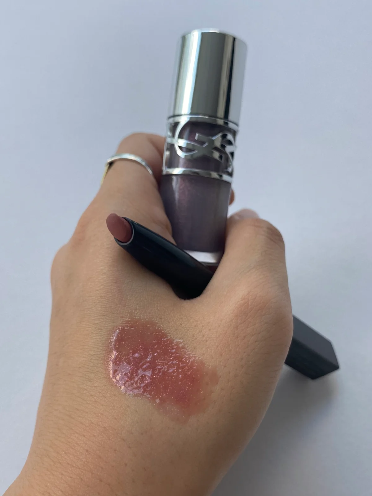 YSL ラブシャイン グロスプランパー 01 とTHREE ドリームオン アリューリング リルone 06を手の甲に重ねたカット