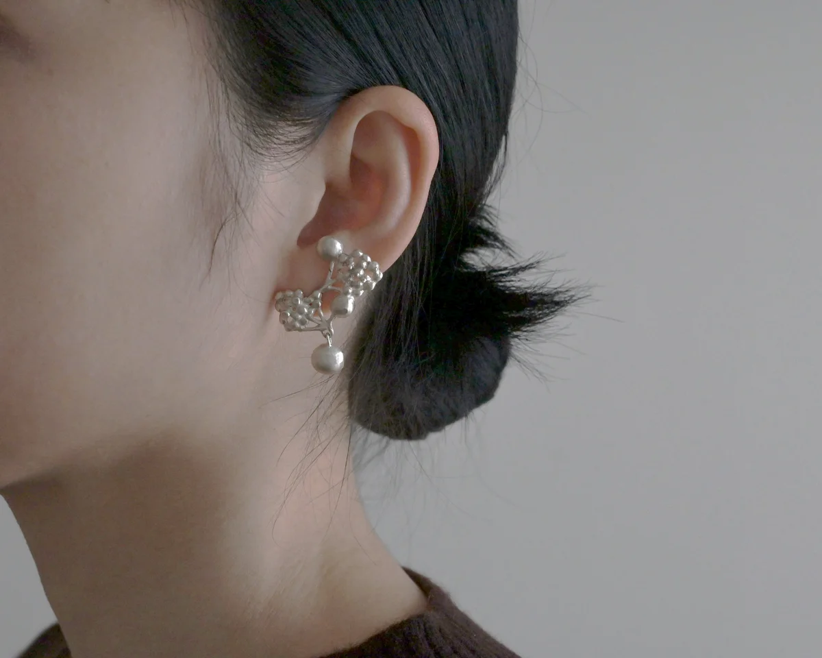 Zoé Mohmのシルバーピアス「PEBBLE CHARMED ACHILLÉE STUDS」 の着用イメージ