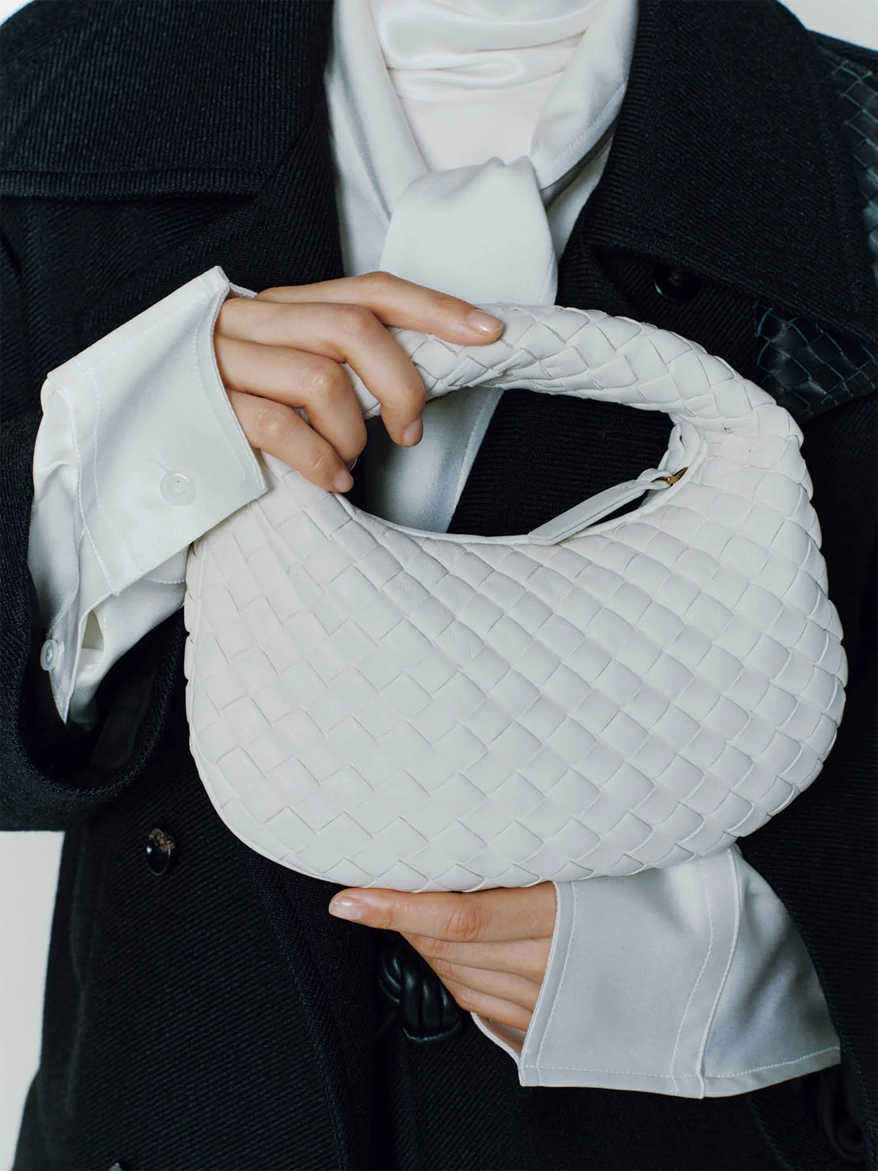 コート￥899,800・シャツ￥479,600・中に着たスリーブレストップス￥220,000・バッグ「ベイビー ヴェネタ」￥478,500／ボッテガ・ヴェネタ ジャパン（ボッテガ・ヴェネタ）