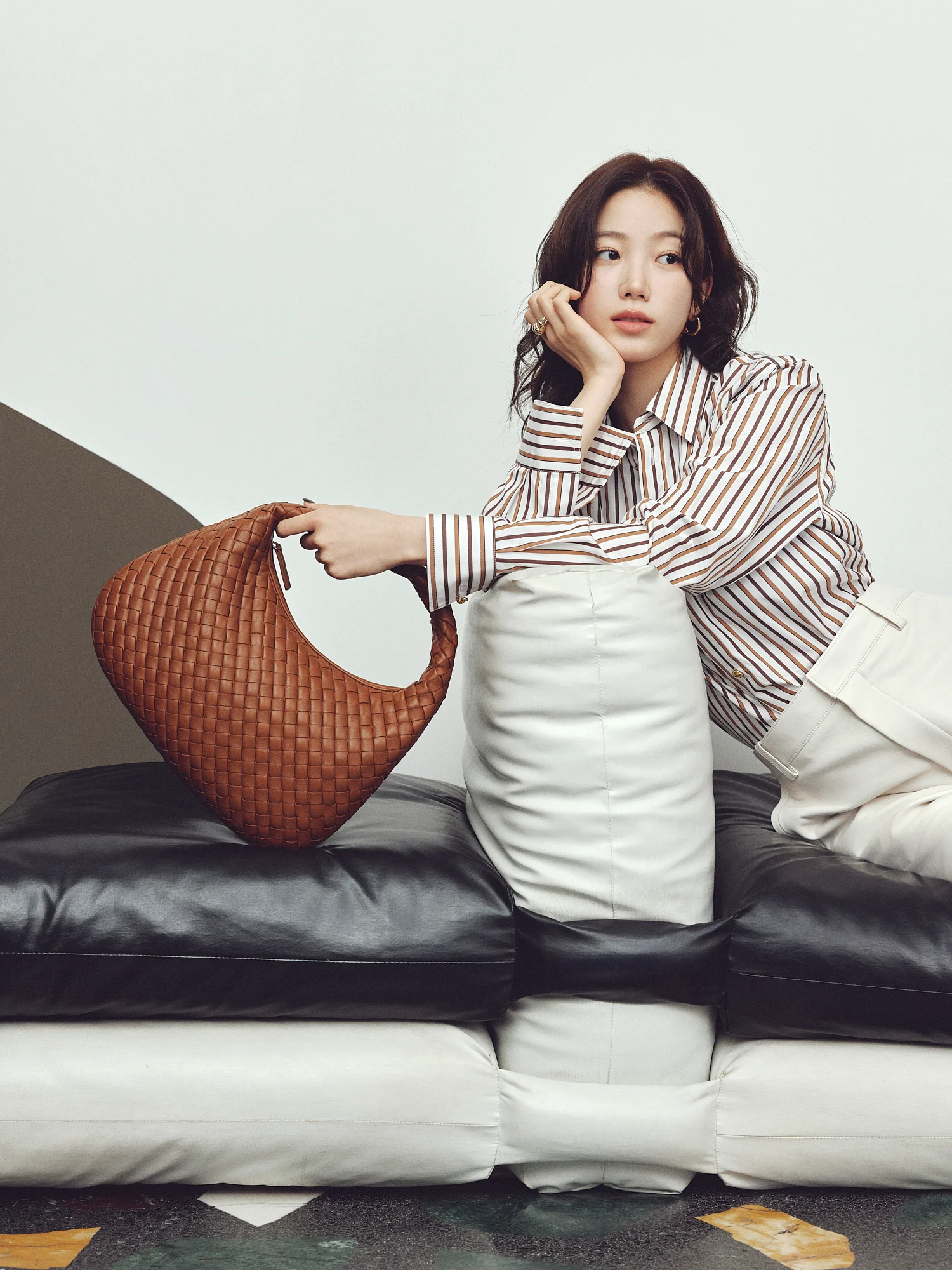 バッグ「スモール ヴェネタ」〈H21×W35×D5cm〉￥654,500・シャツ￥239,800・パンツ￥826,100・リング￥140,000・イヤリング￥106,700／ボッテガ・ヴェネタ ジャパン（ボッテガ・ヴェネタ）